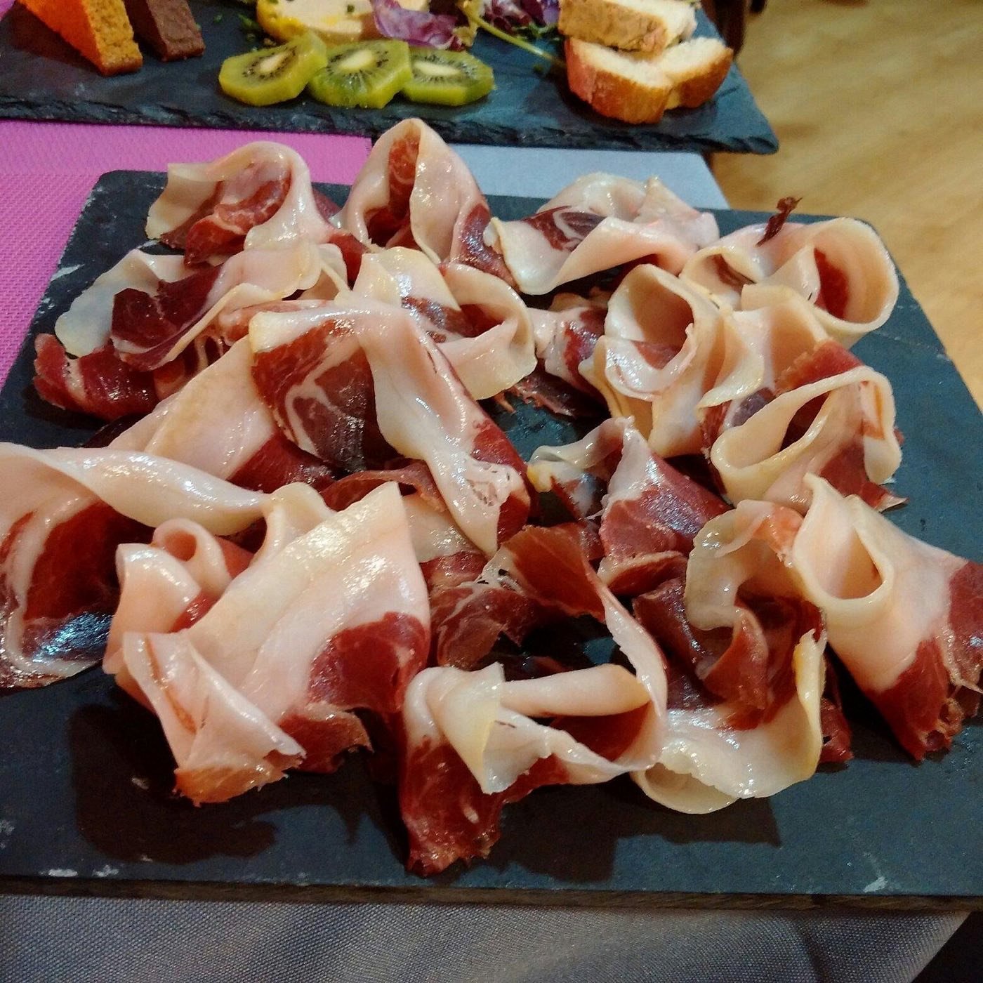 Plat d'embotits ibèrics tallats a mà sobre pissarra